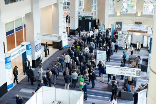 An aerial image of conference attendees networking outside of a conference.