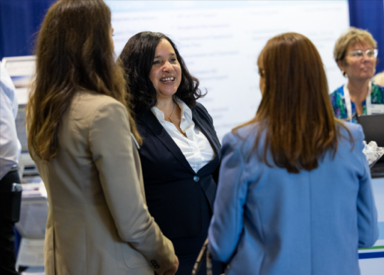 Candid image of ACP's Angie Bell networking with colleagues at an event.